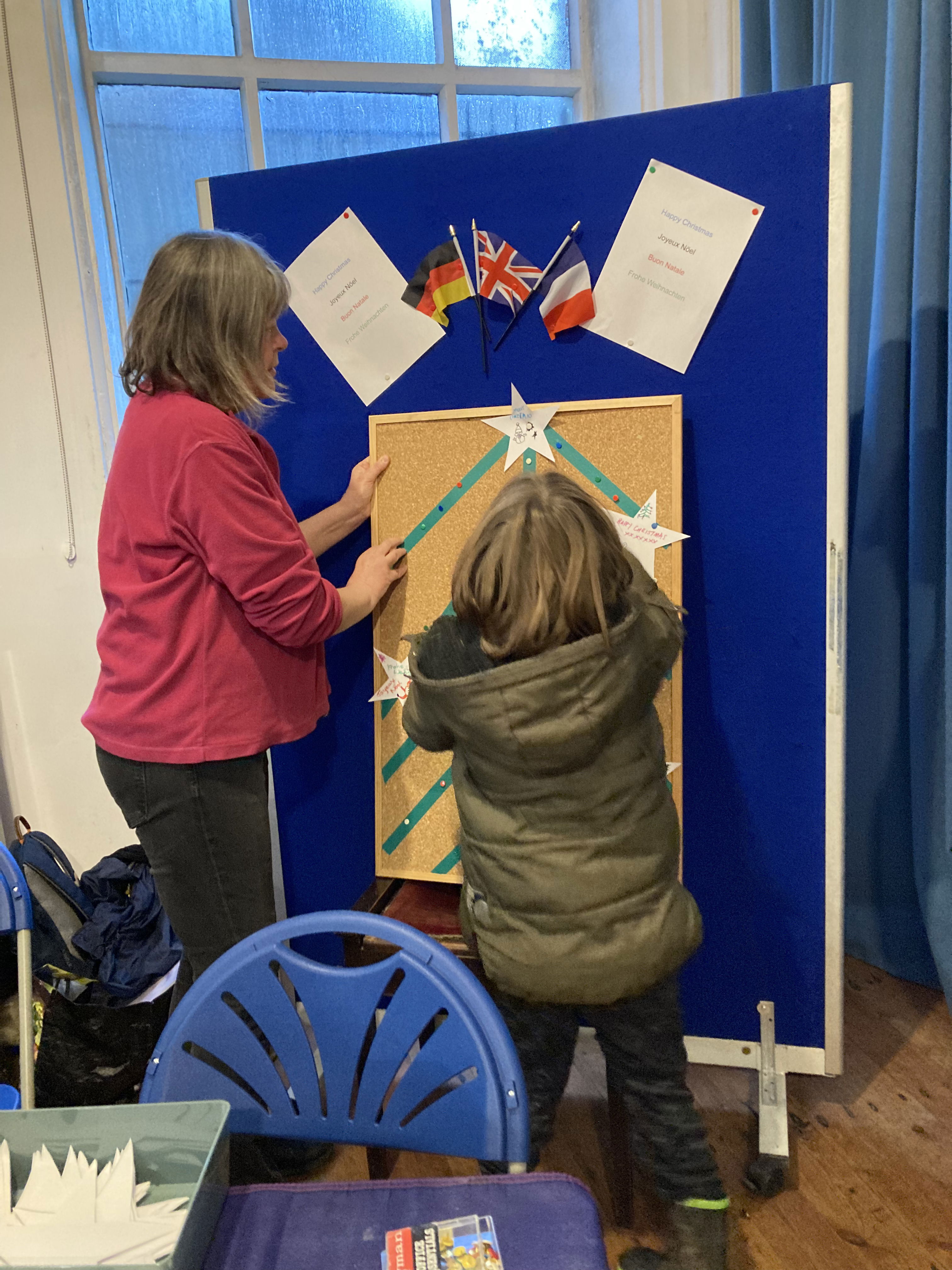 Felicity helping a young visitor to the stall to add her star to the Christmas tree