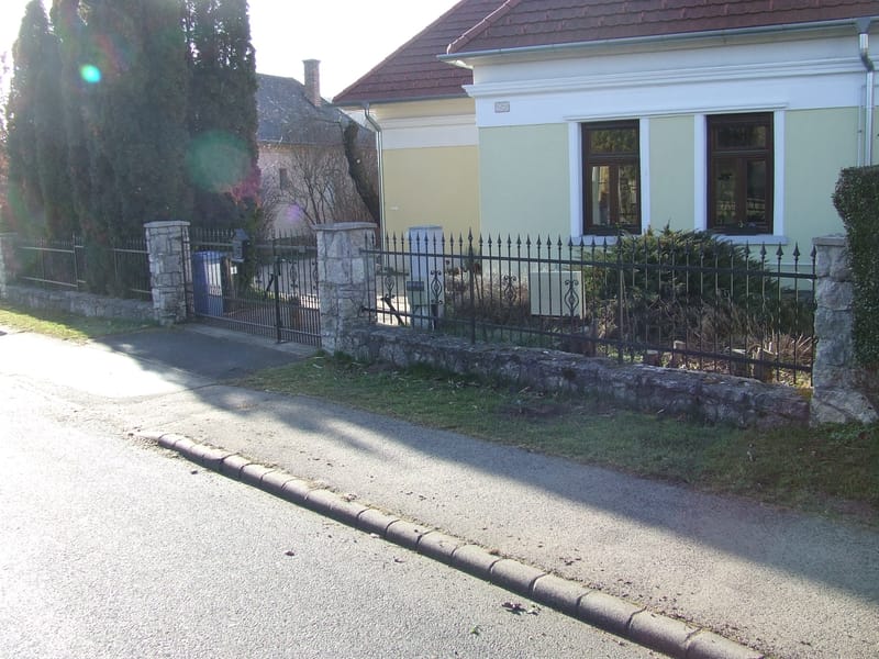 Rakottkő kerítés, kovácsoltvas jellegű kerítéselemekkel, kis és nagykapuval.