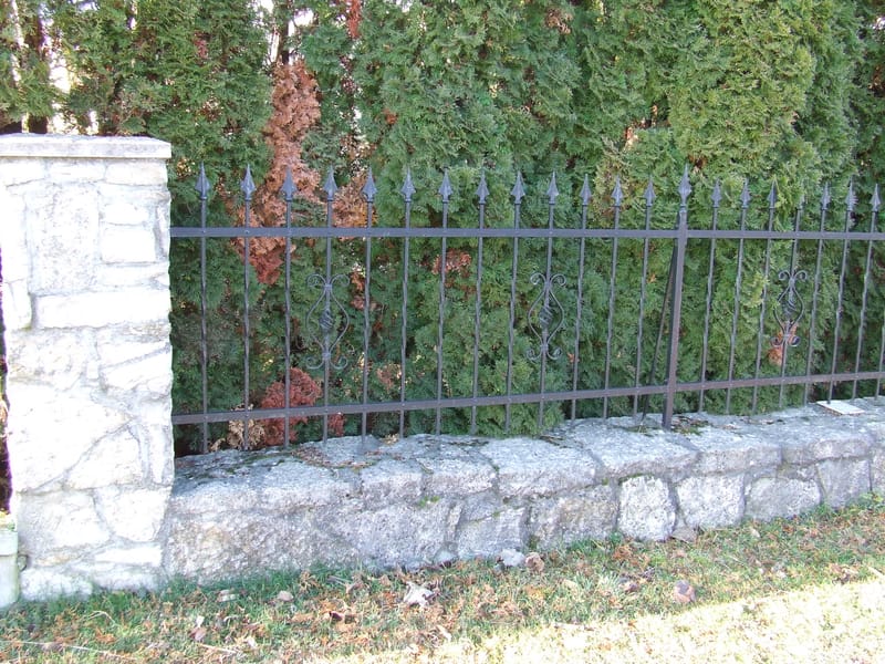 Rakottkő kerítés, kovácsoltvas jellegű kerítéselemekkel, kis és nagykapuval.