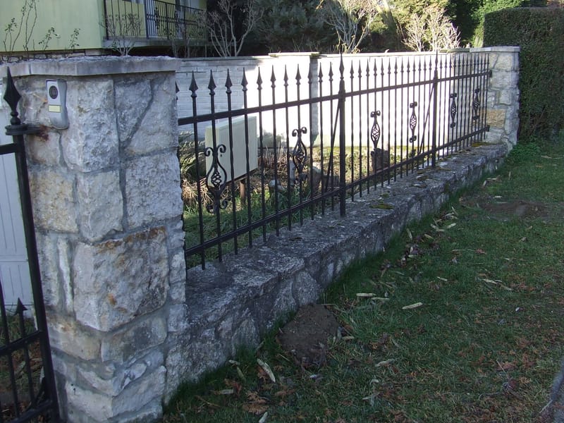 Rakottkő kerítés, kovácsoltvas jellegű kerítéselemekkel, kis és nagykapuval.