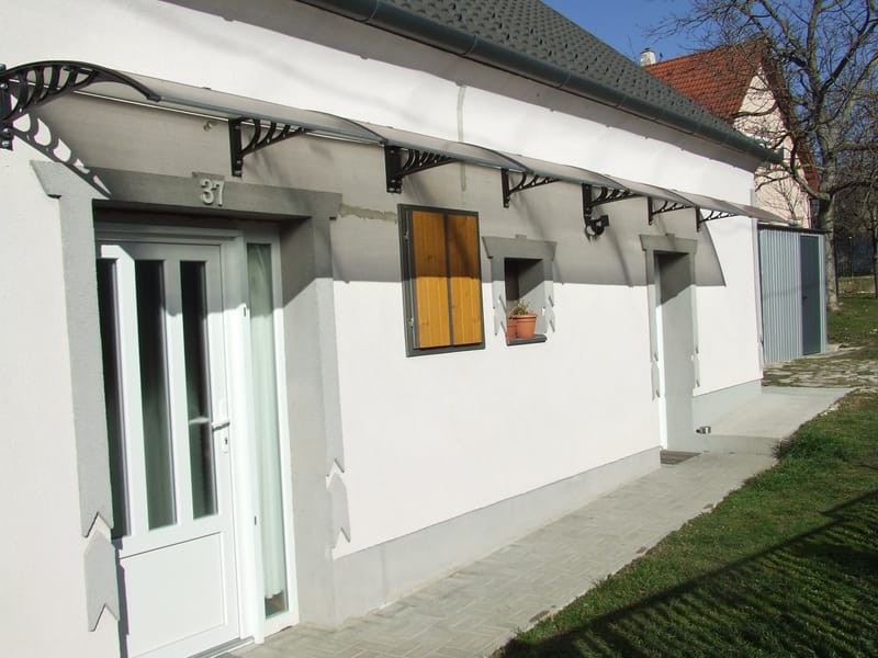 Előregyártott előtető felszerelése kőfalra.