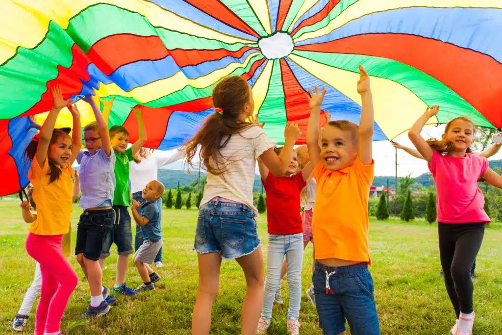Kids playing colorful parachute games at a Toronto daycare party led by our toddler clown entertainment