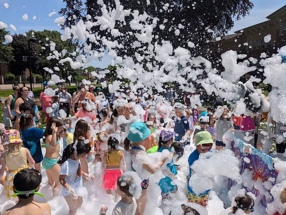 Large group of children playing in soft foam during a big outdoor daycare foam party in Toronto