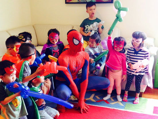 Spider-Man entertaining children with balloon animals at a kids superhero birthday party in Toronto.