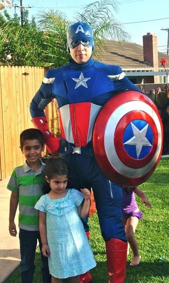 Kids posing with a Captain America party character at a backyard superhero birthday in Toronto.