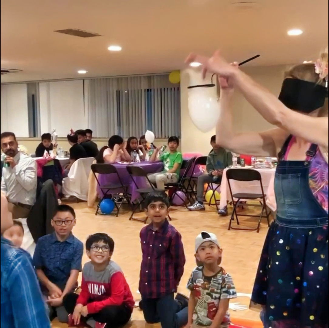 Children watching an indoor bubble show during a kids party in Toronto, with a performer creating floating bubble tricks for the group.
