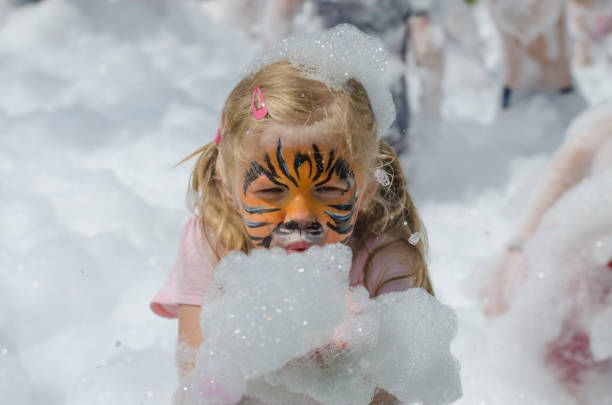 Child with face painting enjoying a kids foam party in Toronto during an outdoor summer celebration