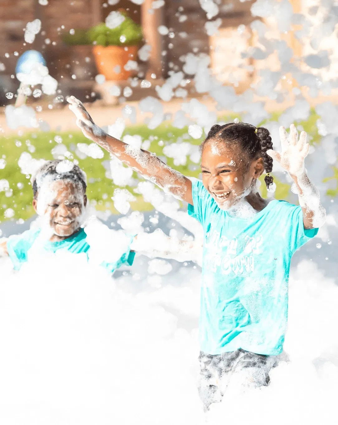 Children laughing and running through foam at a kids outdoor foam party in Toronto