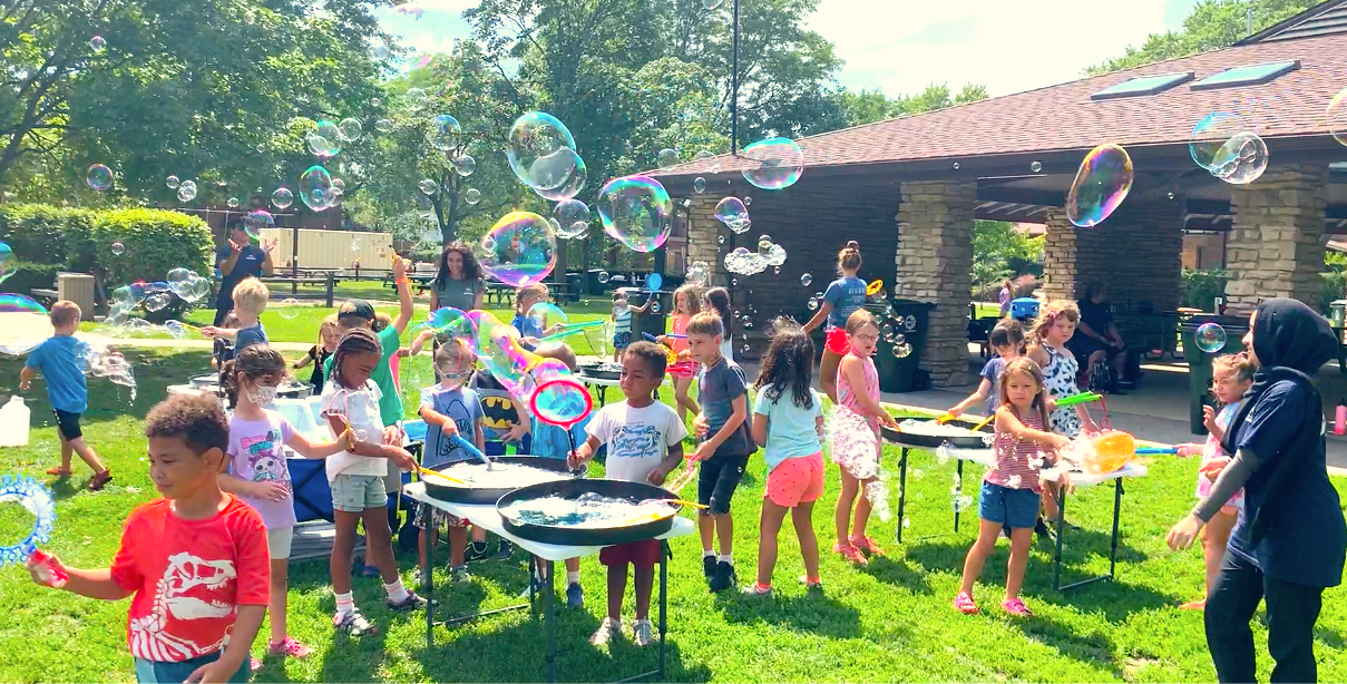 Children enjoying kids bubble shows at an outdoor daycare event in Toronto, featuring interactive children’s entertainment with bubble stations and group play.