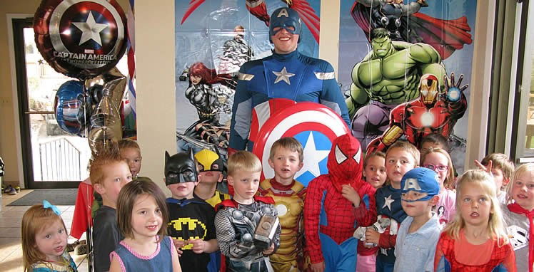 Kids posing with a Captain America party character at a backyard superhero birthday in Toronto.