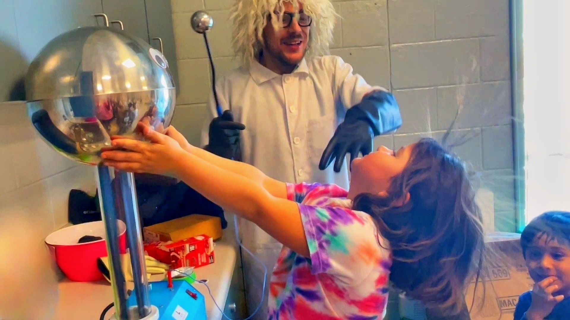 Kids science party in Toronto featuring a child experiencing a Van de Graaff generator electricity experiment during a live Wacky Science Show