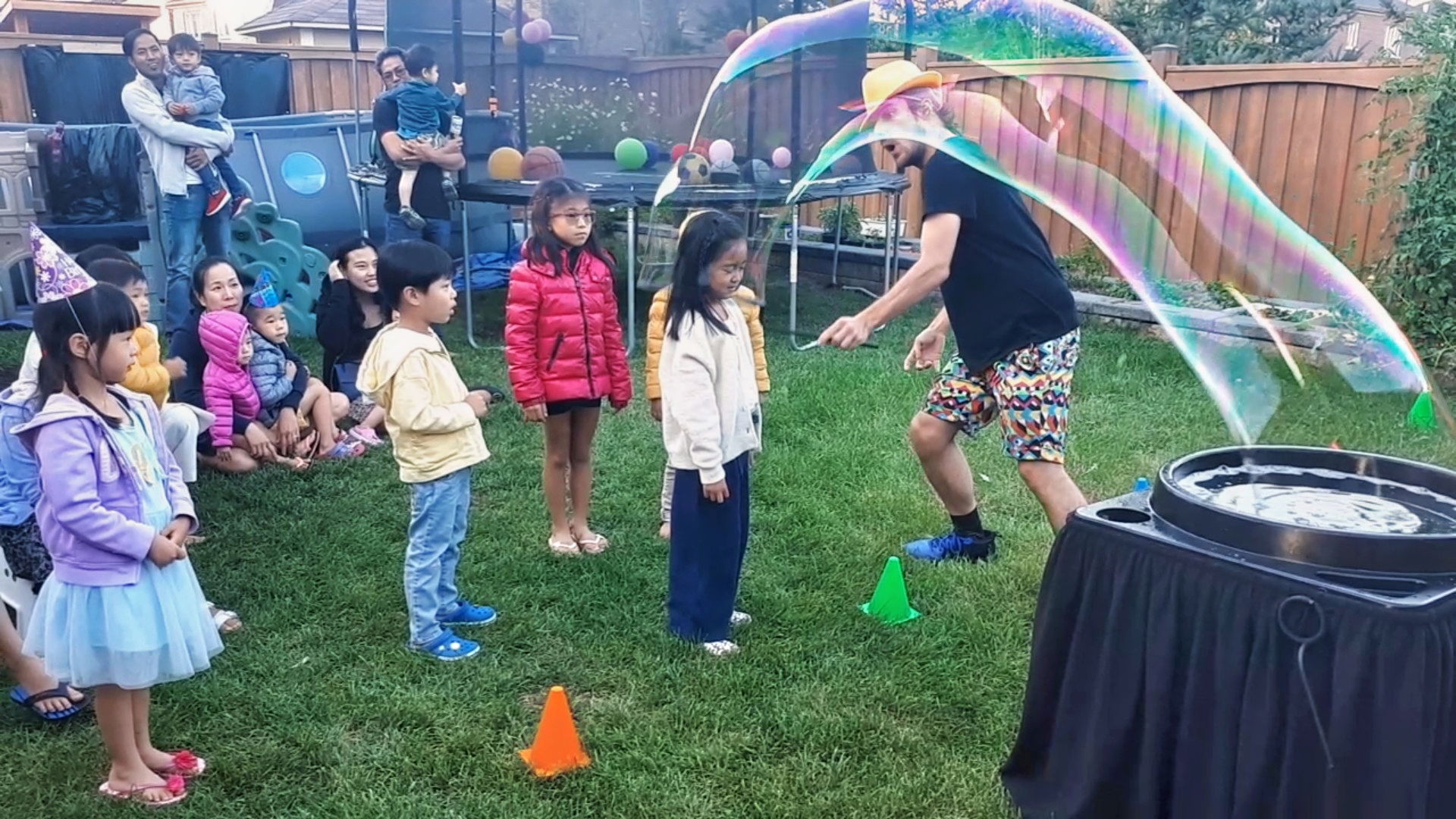 Large outdoor bubble show with children watching giant bubble arc in Toronto