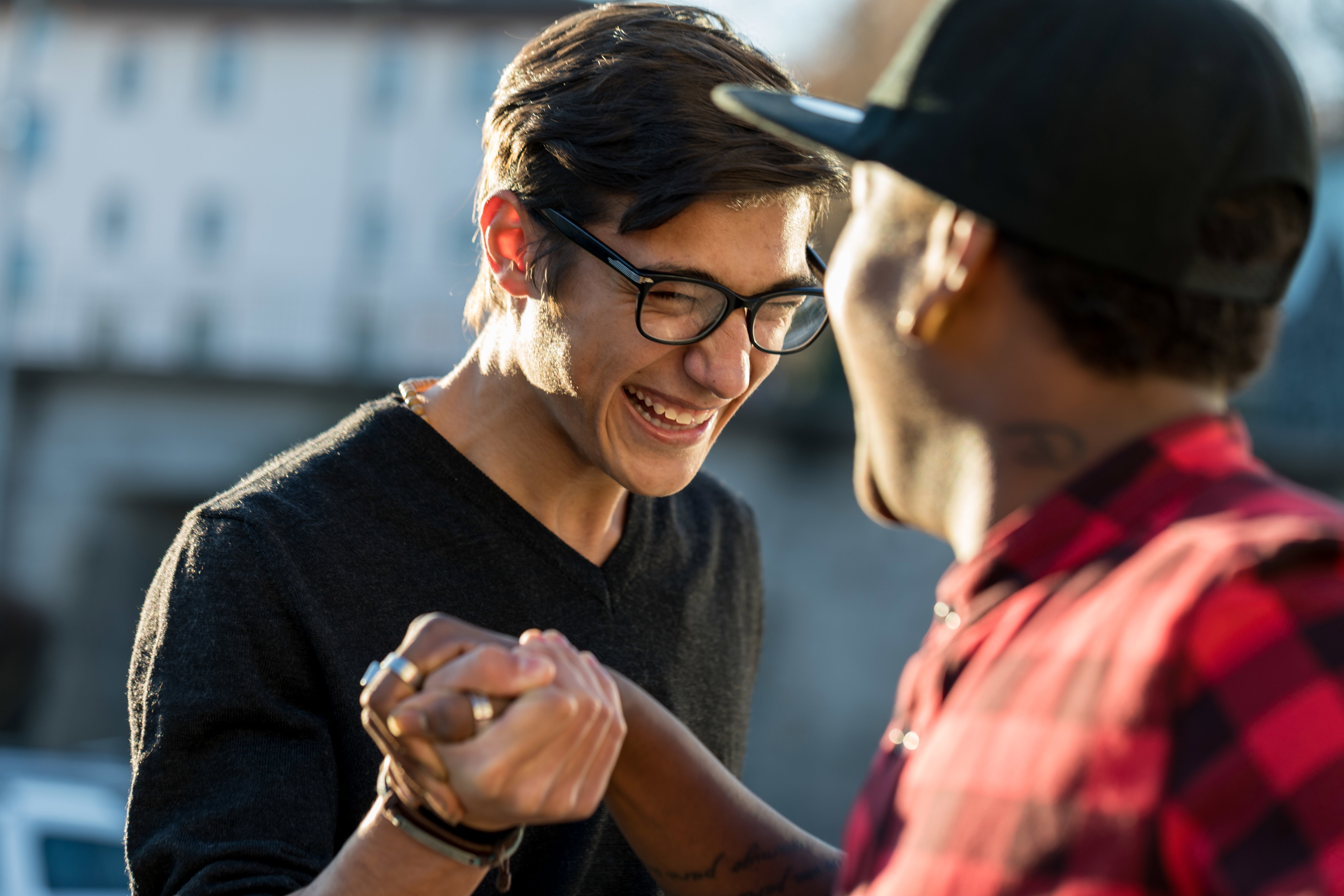 A sober living home director and a resident stand talking and laughing together outside.