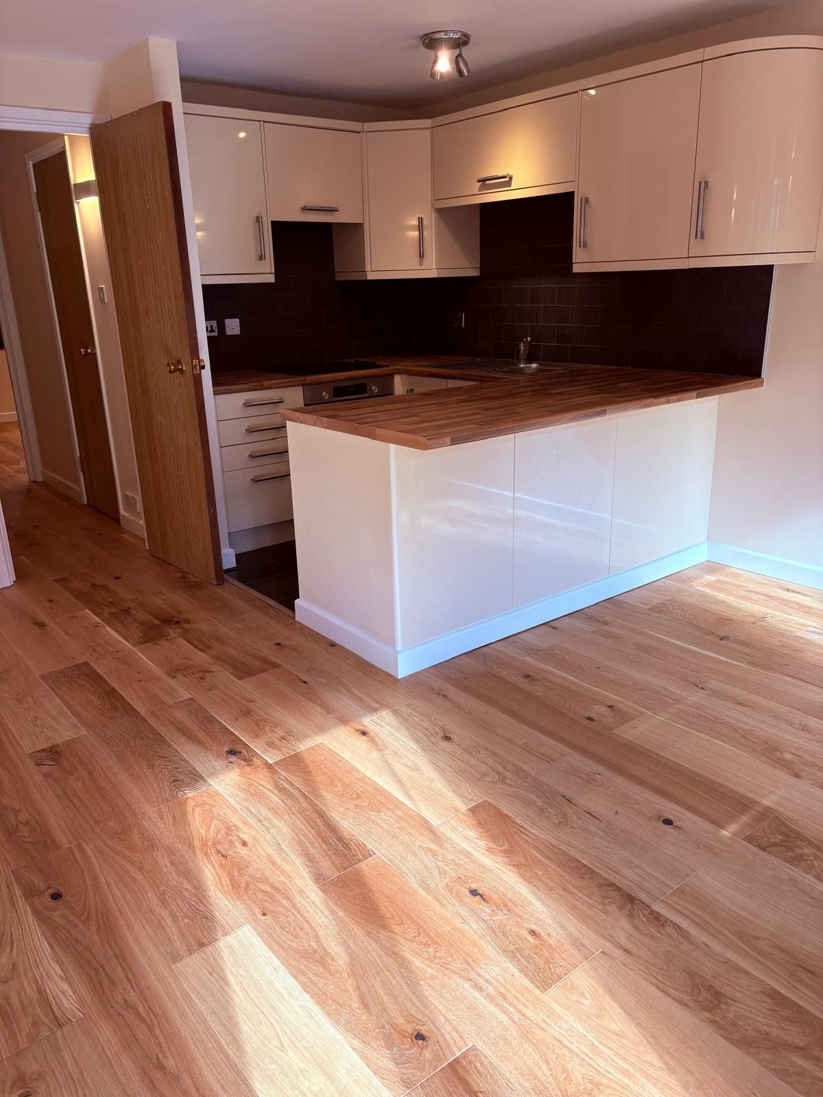 Opened up kitchen to lounge, removed stud wall, redecoration and new engineered wood floor and skirting throughout..