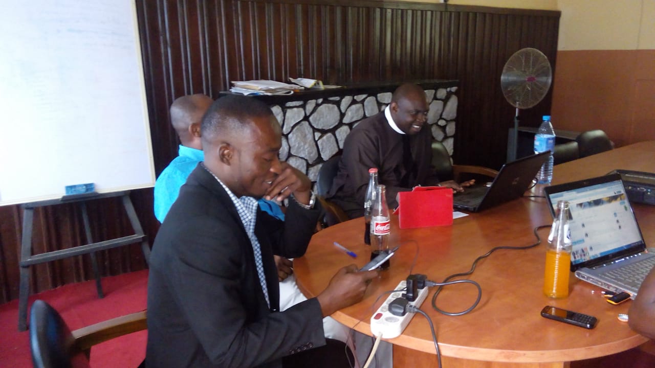 John Pofi, CEO, Holds Meeting with Staff in Office Boardroom