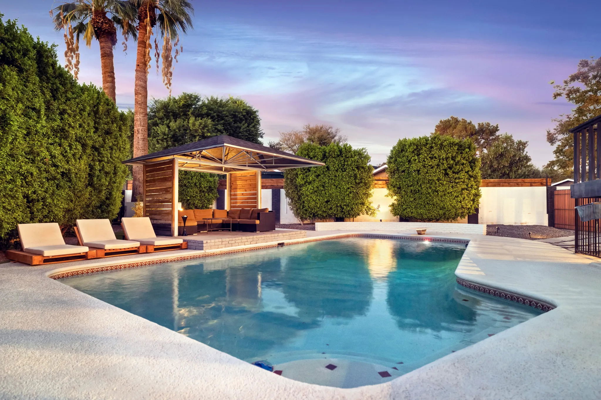 This picture shows the backyard and swimming pool with lounge chairs and cabana area of Embers Recovery sober living home in Phoenix, Arizona.