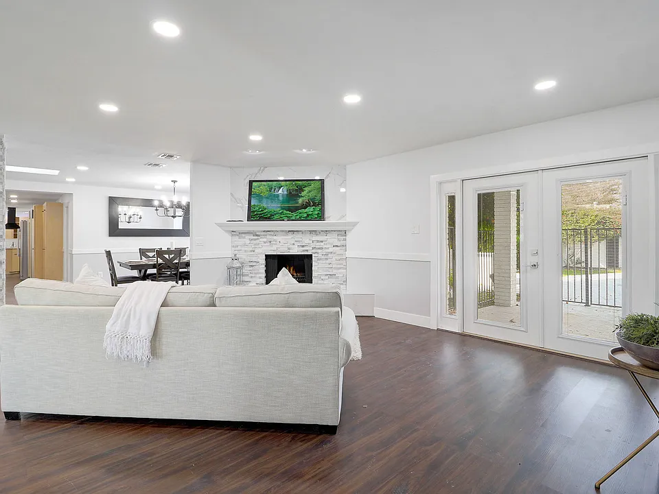 A spacious secondary lounge and community area with large comfortable L-shaped couch in front of a large screen TV at Embers Recovery Center in Phoenix.