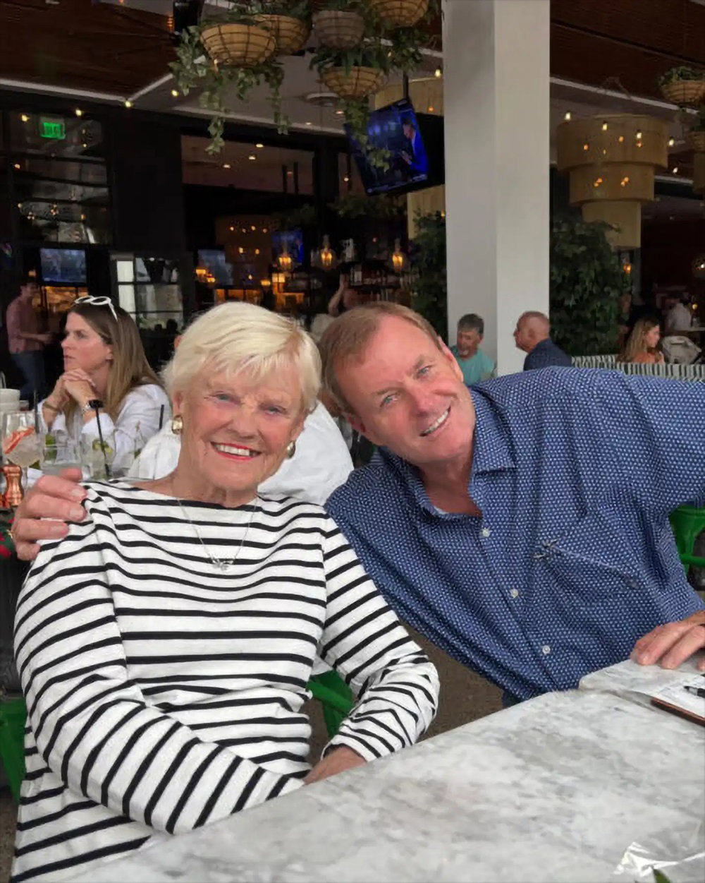 Devin Doyle seated with a family member at a restaurant table indoors