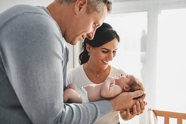 New parents holding an infant in a nursery