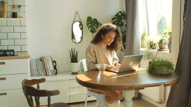 Person working on a laptop at a kitchen table
