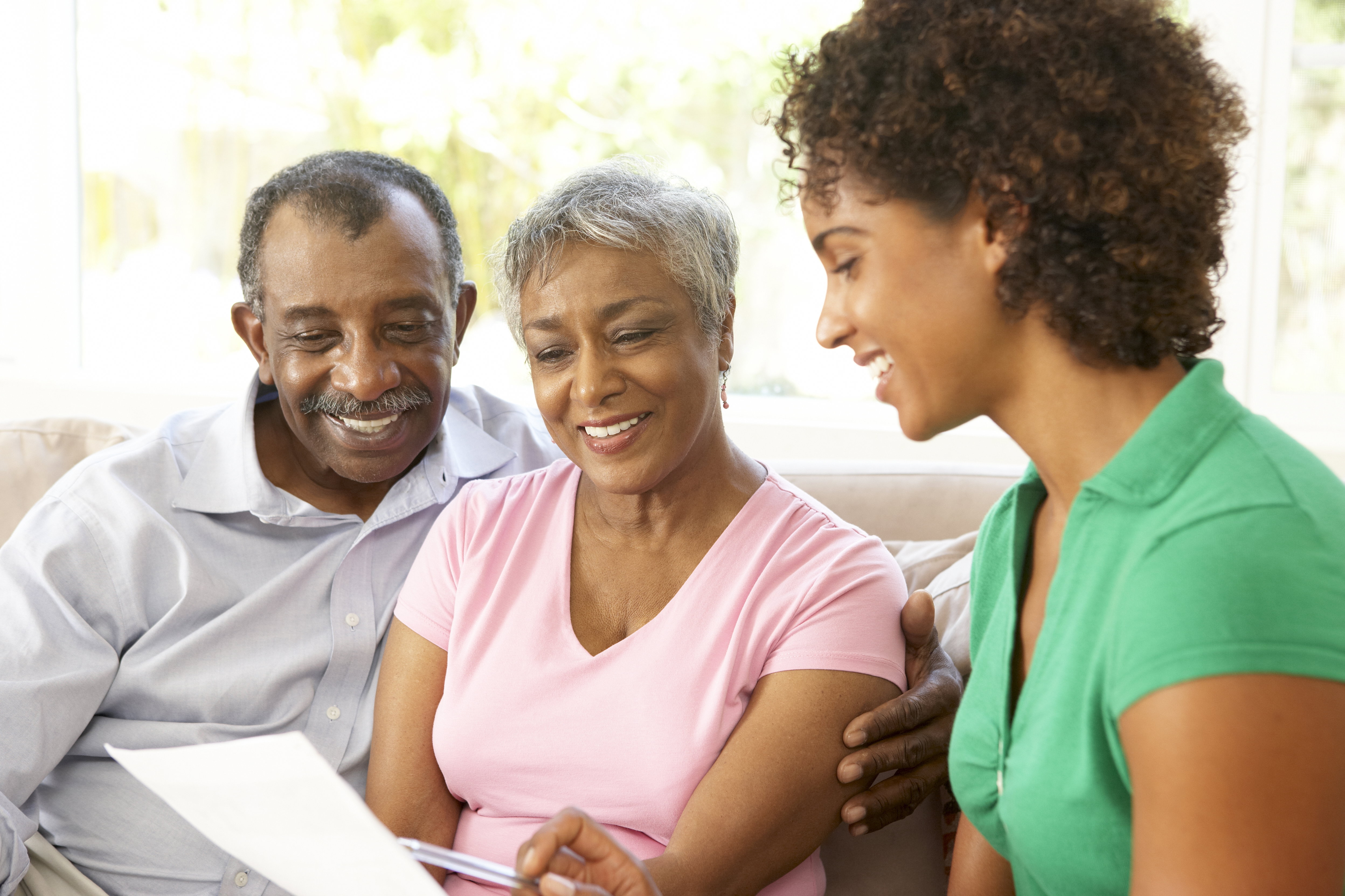Family sitting together reviewing life insurance documents to cover a spouse or parent