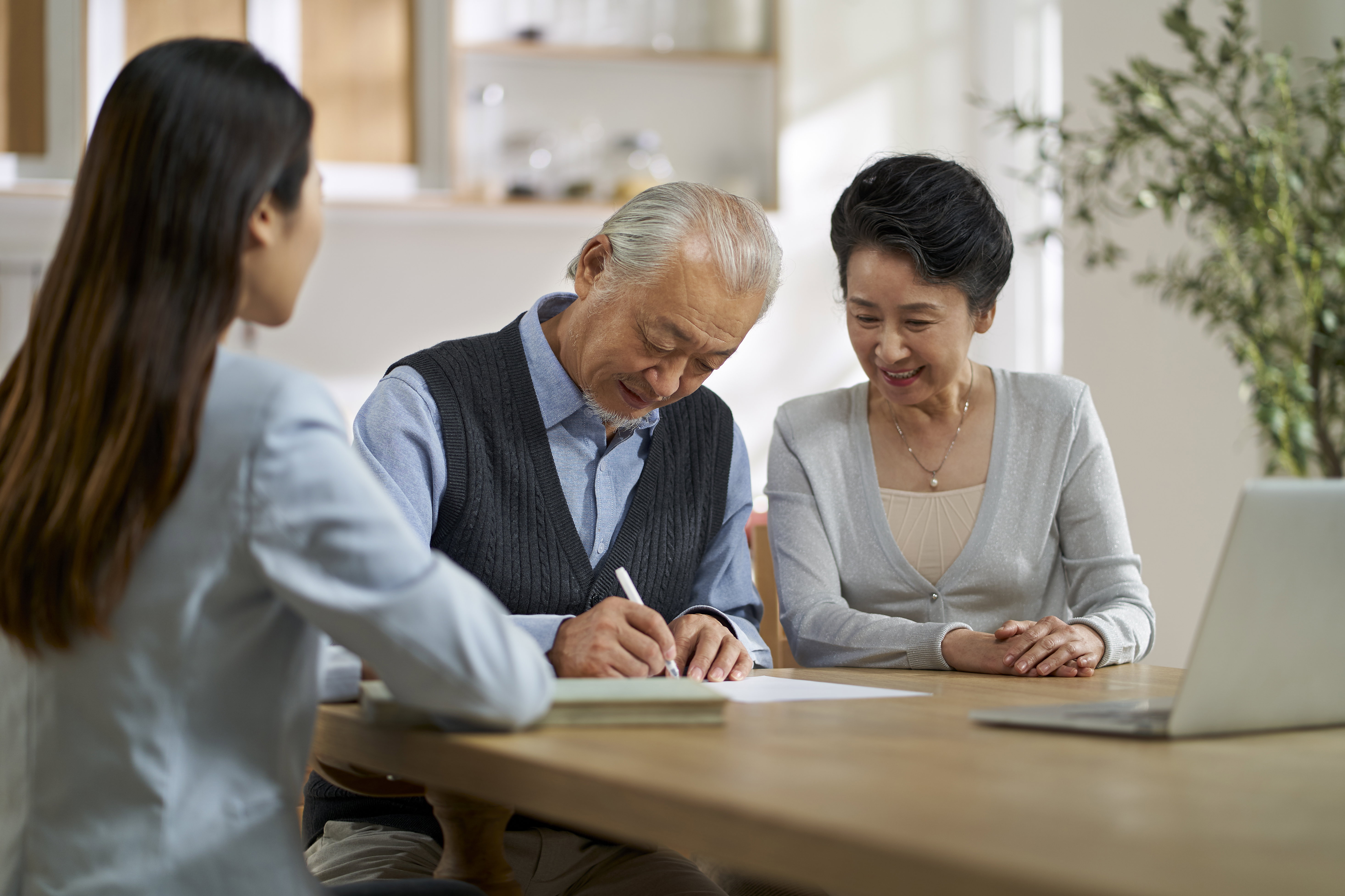 Couple sitting with an insurance advisor discussing spousal life insurance coverage options