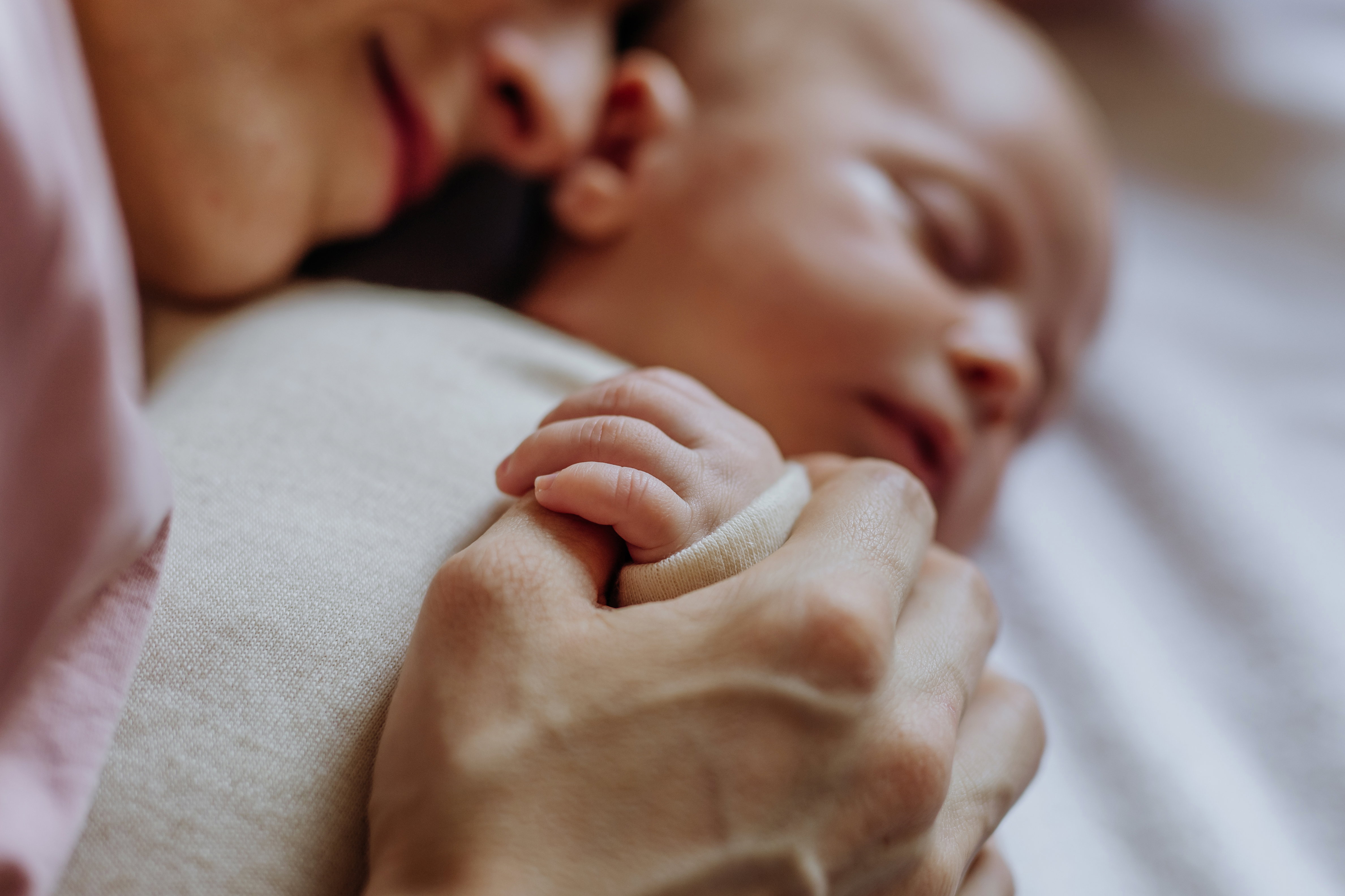 Parent holding sleeping newborn